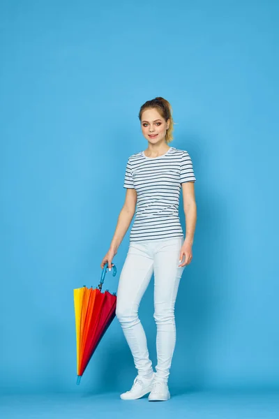 Hezká žena móda pózování barevný deštník modré pozadí — Stock fotografie