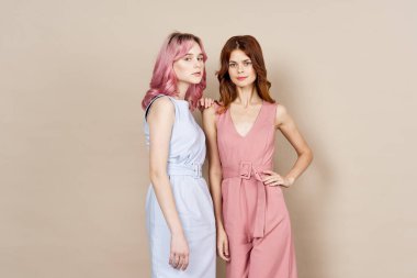 İki kız arkadaş yan yana durur. Lüks bir yaz pozu verir.