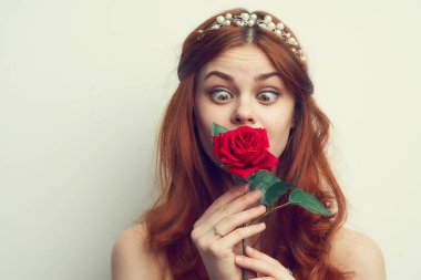 Kızıl saçlı güzel bir kadın. Kırmızı gül çiçeği. Yaklaş.