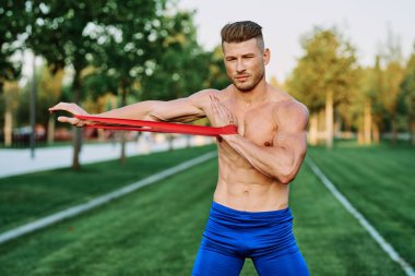 Parkın spor salonunda şişkin vücutlu atletik bir adam.