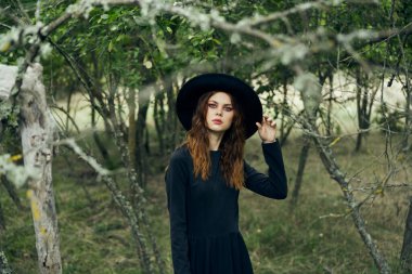 Cadılar Bayramı 'nda cadılar bayramı için ormanda poz veren cadı.