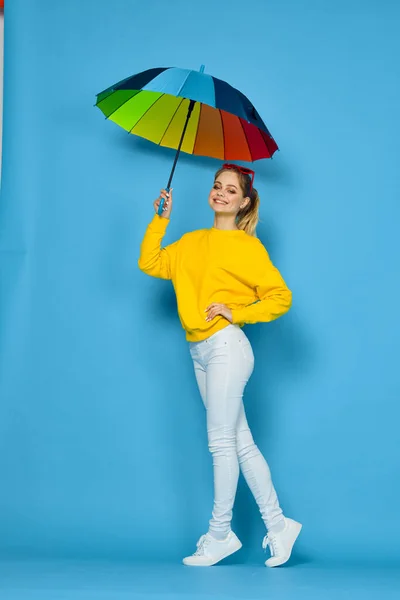 Kvinna med flerfärgat paraply i gul tröja poserar regnbågens färger — Stockfoto