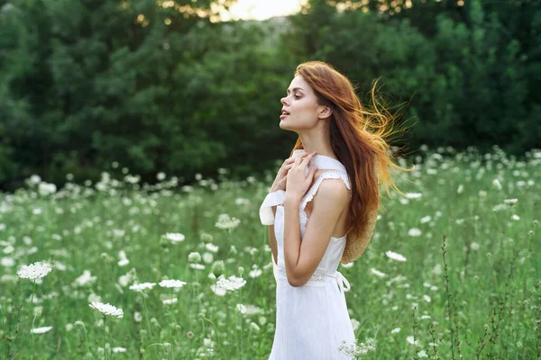 Mulher de vestido branco em um campo andar flores vintage natureza — Fotografia de Stock