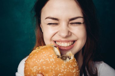 Hamburger yiyen bir kadın.