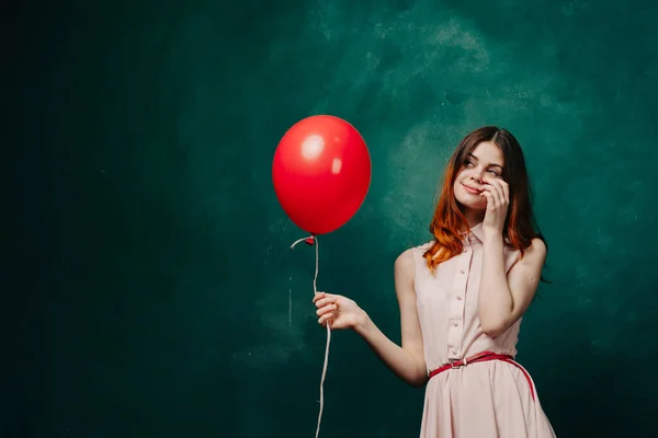 Vrolijke vrouw met rode ballon groene achtergrond vakantie — Stockfoto