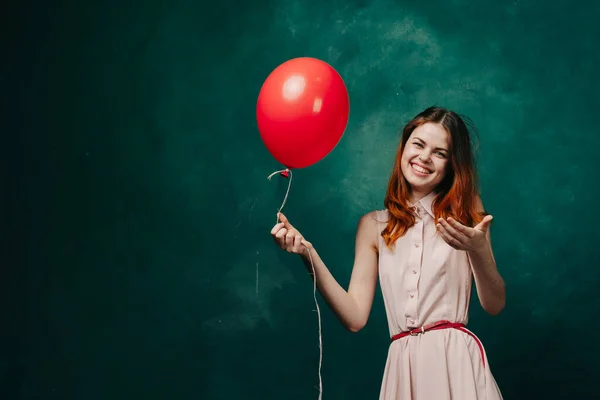 Fröhliche Frau mit rotem Ballon grünen Hintergrund Urlaub — Stockfoto