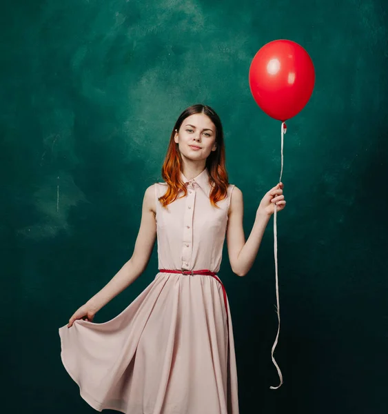 Bonita mujer en vestido rojo globo cumpleaños verde fondo — Foto de Stock