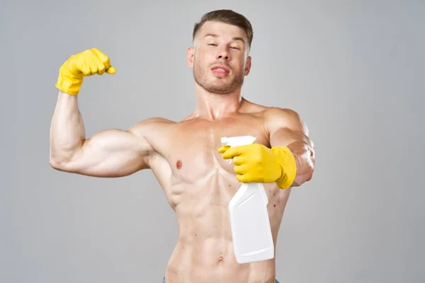 Запечений чоловік позує з миючим засобом в гумових рукавичках — стокове фото