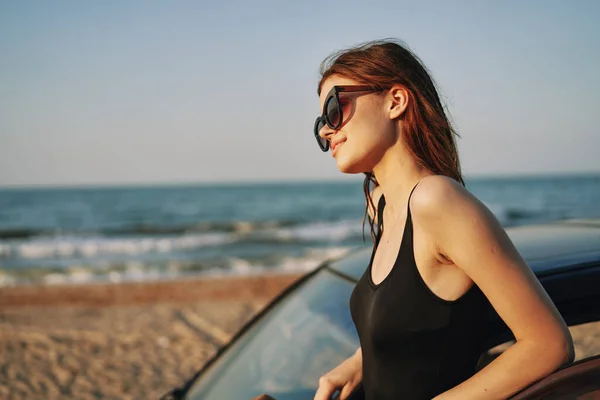 Frau am Strand ist mit Auto mit Sonnenbrille unterwegs — Stockfoto