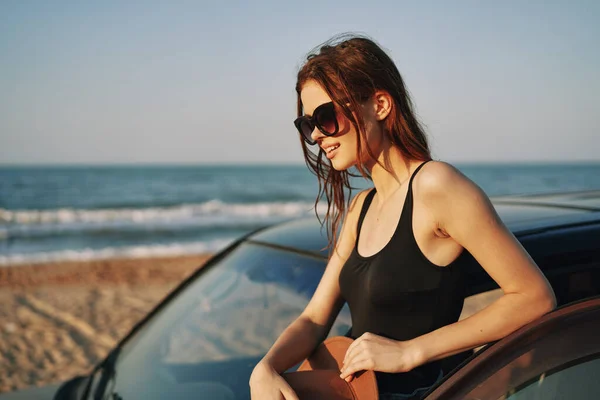 Γυναίκα στην παραλία είναι με ένα αυτοκίνητο φορώντας γυαλιά ηλίου ταξίδια — Φωτογραφία Αρχείου