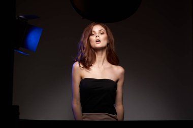 Fotoğraf stüdyosu çeken bir kadının portresi açık siyah arka plan pozu veriyor.