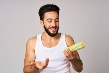 Elinde mısırla sakallı bir adam taze sebzeler sağlık sigortası