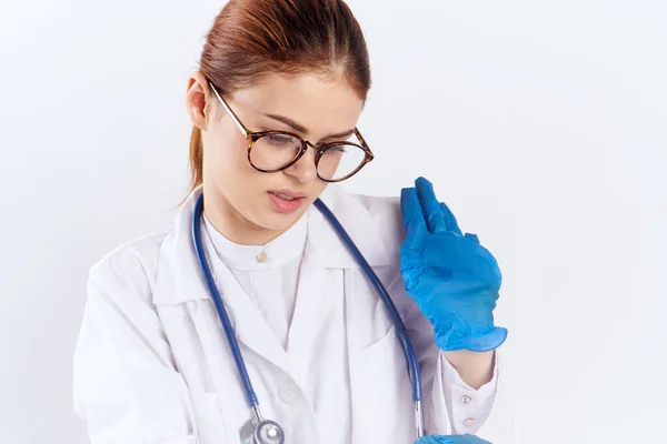 Γυναίκα γιατρός κάθεται στο τραπέζι με μπλε γάντια φαρμακευτικές δοκιμές — Φωτογραφία Αρχείου