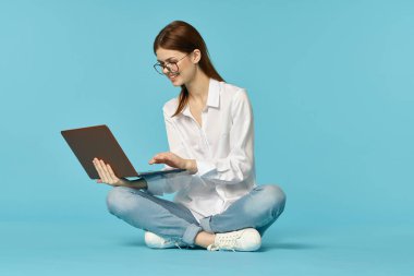 Dizüstü bilgisayarı olan kadın internet eğitimi mavi arka plan