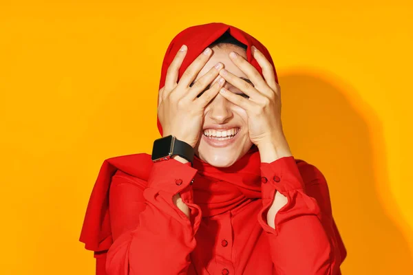 Жінка в червоному хіджабі з годинником в руках технологія емоції студійний спосіб життя — стокове фото