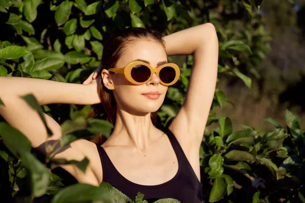 Bonita mujer en traje de baño negro gafas de sol verde deja la naturaleza —  Fotos de Stock