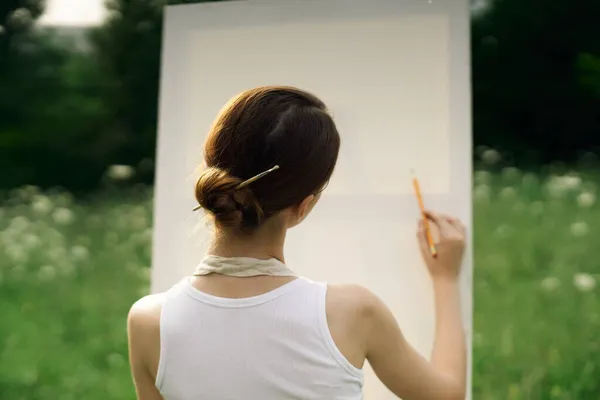 Önlüklü kadın sanatçı bir resim çiziyor. — Stok fotoğraf