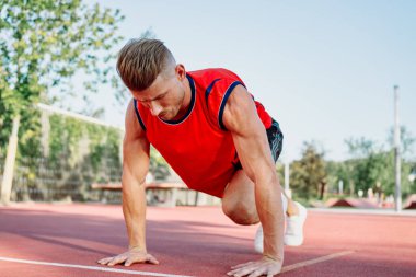 Spor sahası egzersizlerinde kaslı sporcular.