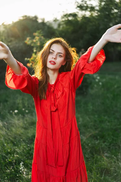 Attraente donna in abito rosso all'aperto in campo di libertà — Foto Stock