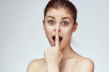 Çıplak omuzlu kadın yüz kremi cilt bakımına yakın çekim