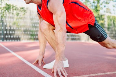 Spor sahasında spor yapan atletik bir adam.
