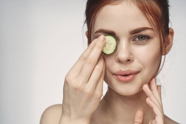 Çıplak omuzlu çekici bir kadın. Salatalık cilt bakımı.