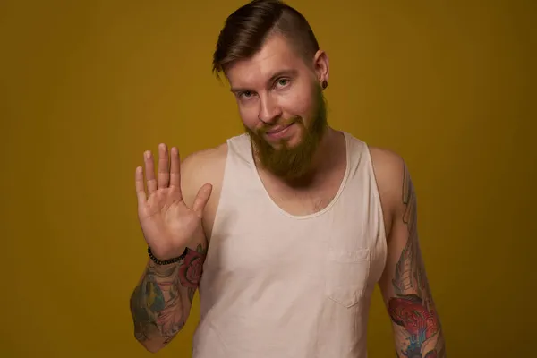 Hombre barbudo alegre en una camiseta blanca con tatuajes hooligan en sus brazos — Foto de Stock