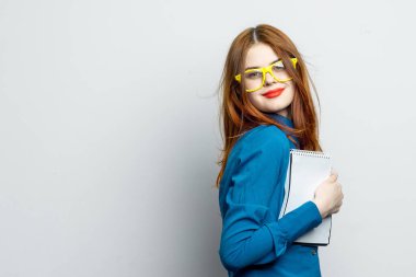 Not defteri ve kalem takan, sarı gözlüklü profesyonel bir iş kadını.