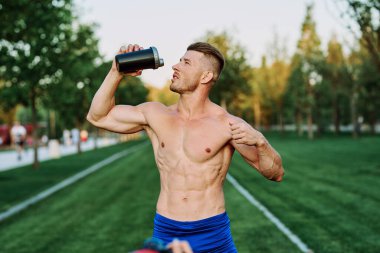 Parktaki egzersiz motivasyonunda kaslı vücutlu atletik bir adam.