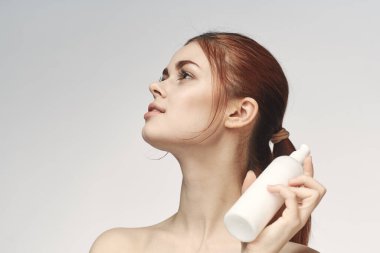 Ellerinde losyon olan kadın cilt bakımını temizliyor.