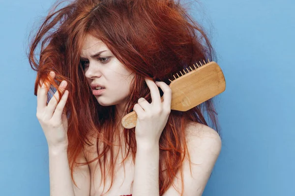 赤い髪の櫛のケアブルーの背景を持つ女性 — ストック写真
