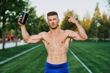 Parktaki egzersiz motivasyonunda kaslı vücutlu atletik bir adam.