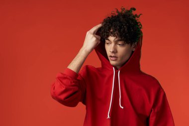 Kırmızı kazaklı bir adam kalp tatilinde poz veriyor.