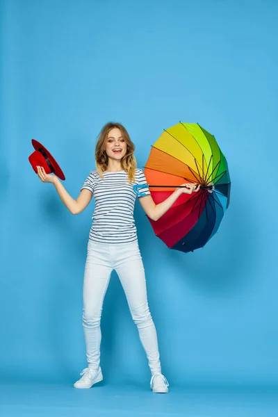 Hübsche Frau Mode posiert bunten Regenschirm blauen Hintergrund — Stockfoto