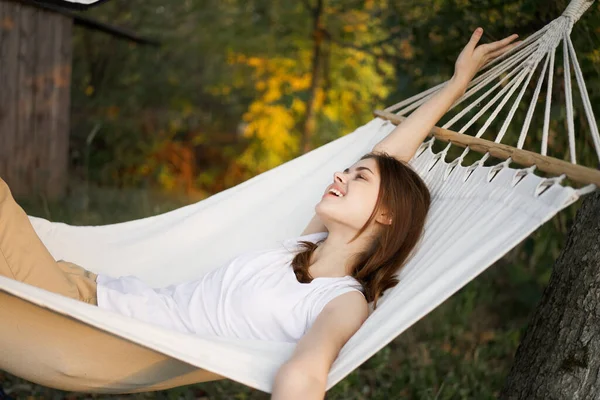 Glad kvinna ligger i en hängmatta vila natur frisk luft — Stockfoto