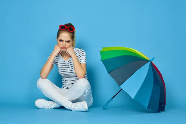 Vacker kvinna mode poserar färgglada paraply blå bakgrund — Stockfoto