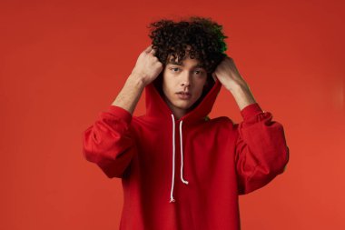 Kırmızı kazaklı bir adam kalp tatilinde poz veriyor.