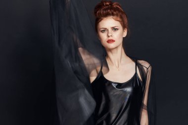 Siyah elbiseli zarif bir kadın kozmetik poz veriyor.