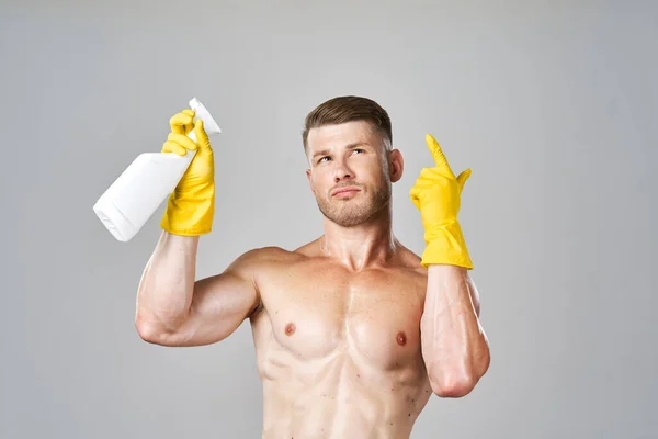 Bombeado hombre posando con detergente en guantes de goma —  Fotos de Stock