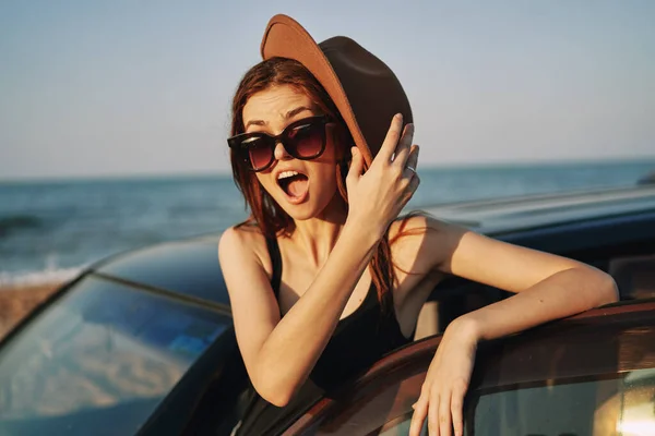 Frau am Strand ist mit Auto mit Sonnenbrille unterwegs — Stockfoto