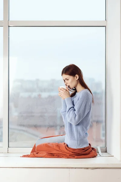 Mujer cerca de la ventana mirada de ensueño descanso en el hogar comodidad — Foto de Stock