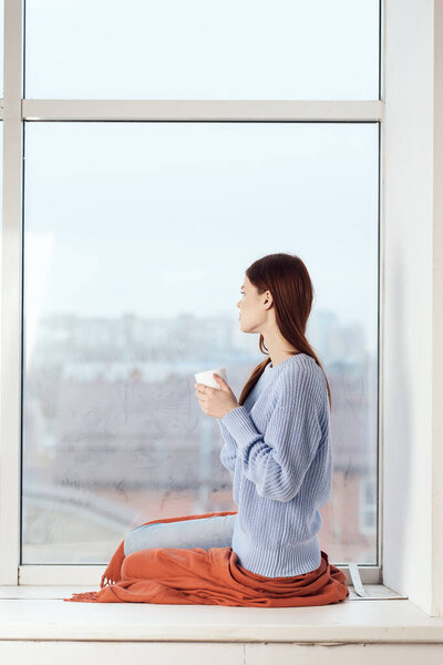 woman near the window dreamy look rest at home comfort