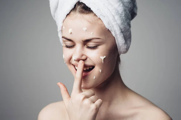 Donna con asciugamano spalle nude sulla testa crema viso cura della pelle — Foto Stock