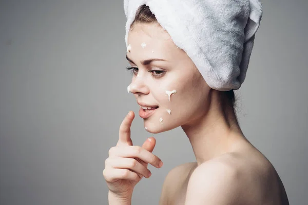 Женщина с голыми плечами полотенце на голове крем для лица уход за кожей — стоковое фото