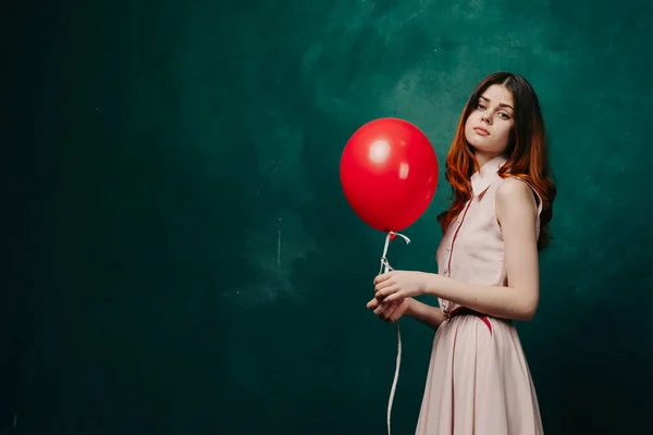 Bonita mujer en vestido rojo globo cumpleaños verde fondo — Foto de Stock