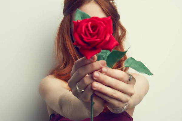 Hermosa mujer con el pelo rojo rosa roja flor de cerca —  Fotos de Stock