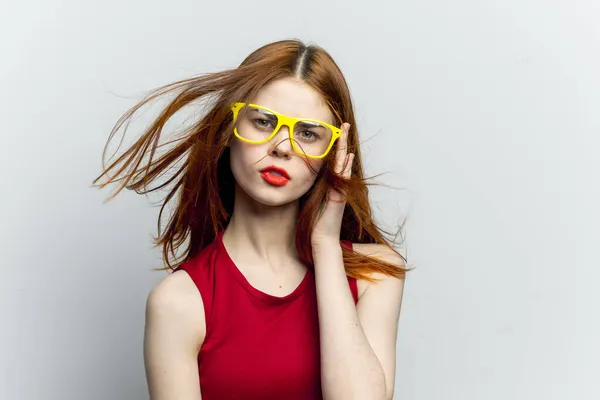 感情的な女性で赤いドレス黄色のメガネポーズ — ストック写真