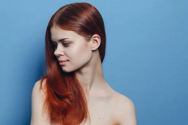 Рыжая женщина голые плечи уход за волосами синий фон — стоковое фото