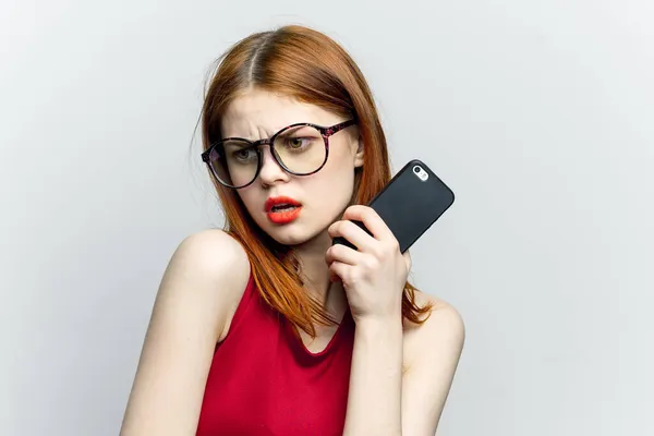아름다운 여인 이 안경을 끼고 손에 전화기를 들고 의사소통 기술을 가지고 있다 — 스톡 사진