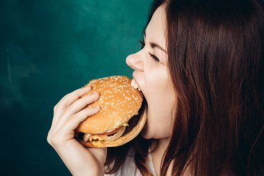 Hamburger yiyen bir kadın.